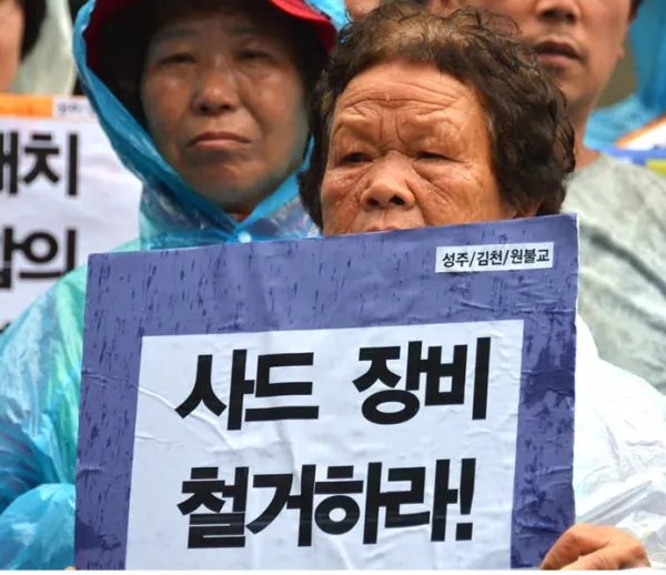 为什么韩国民众冒雨抗议呢?